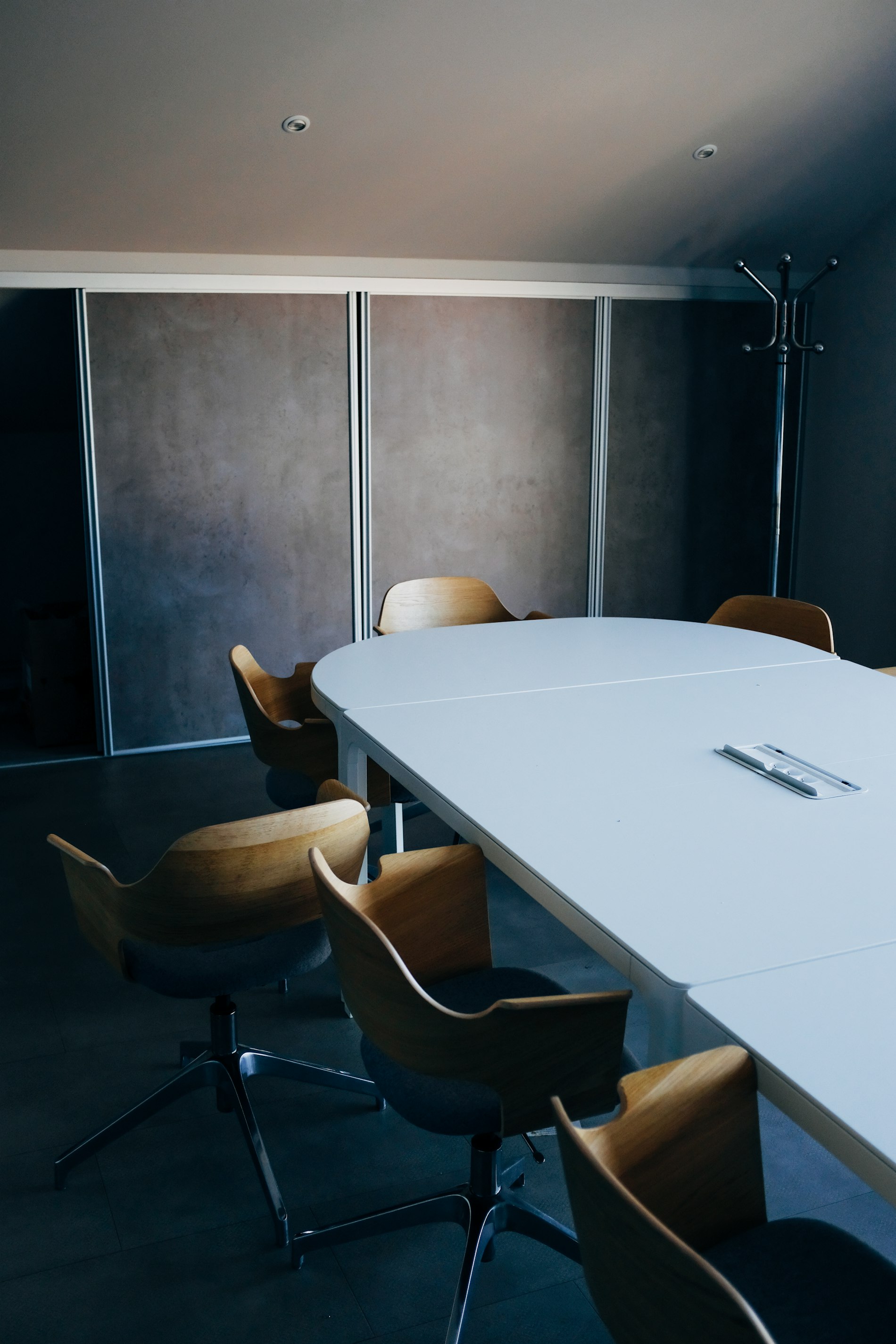Salle de conseil feutrée aux tons gris-bleu, cadre structuré et posé